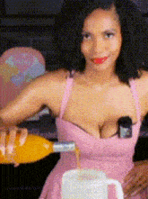 a woman in a pink dress is pouring orange juice into a measuring cup