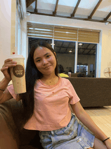 a woman sitting on a couch holding a cup that says apavan tea