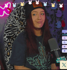 a woman giving a peace sign in front of a microphone with a sticker that says ' to lazy bastards '