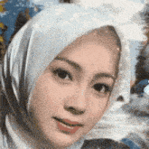 a close up of a woman wearing a white scarf around her head