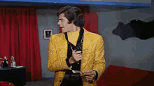 a man in a yellow jacket is holding a bottle in his hand