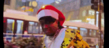 a man wearing a santa hat is walking down the street