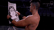 a wrestler holds up a drawing of a woman with the words " you 're the best " written on it