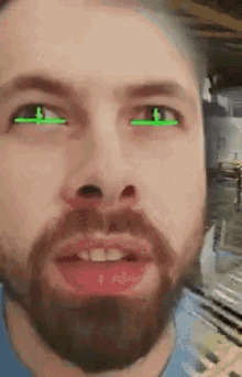 a man with a beard and green eyes is looking at the camera