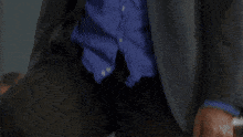 a man in a suit and blue shirt is making a face