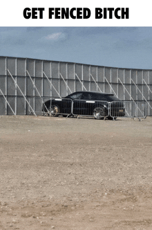 a car is parked in front of a fence with the words get fenced bitch above it