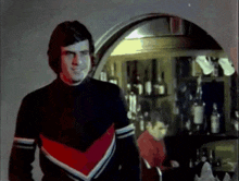 a man in a black sweater with red white and blue stripes