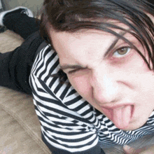a person wearing a black and white striped shirt with their tongue out