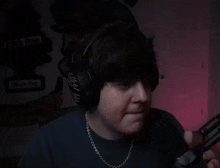 a close up of a man wearing headphones and making a funny face .