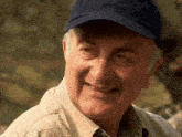 a man wearing a blue hat with the letter t on it is smiling