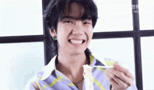 a young man is eating a piece of food with a fork .