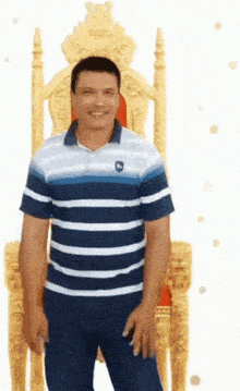 a man in a blue and white striped shirt is standing in front of a throne