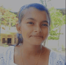a young girl is smiling for the camera and wearing a headband .