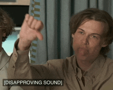 a man giving a thumbs down sign with disappointing sound written underneath him