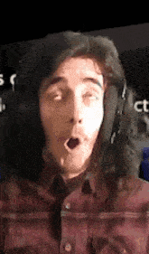 a man with long hair is wearing headphones and making a surprised face