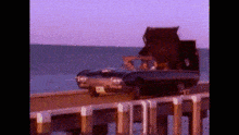 a car is parked on a dock near the ocean .