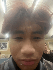 a close up of a man 's face with a piercing on his lip
