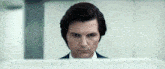 a man in a suit is looking at a monitor