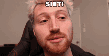 a man with a red beard has the word shit on his forehead