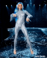 a drag queen is dancing in the water on a stage .