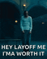 a man with a mustache is standing in a dark room and saying hey layoff me i 'm worth it