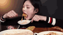 a woman is eating a plate of food with a fork