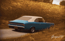 a blue and white car is driving down a road with the name gangas 272 on the bottom right