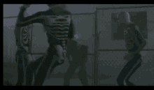 a group of people dressed as skeletons are standing next to each other in a foggy room .