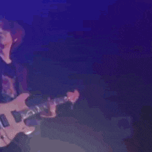 a blurry picture of a man playing a guitar in a dark room