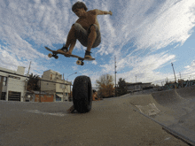 a skateboarder is doing a trick with a tire in the foreground