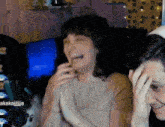 a man and a woman are laughing in front of a screen that says " kakajiija "
