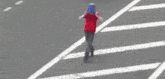 a person wearing a blue bucket on their head is crossing the street .
