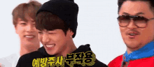a group of people are standing next to each other and one of them is wearing a black beanie .