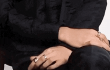 a close up of a person 's hands wearing rings .
