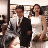 a man in a suit and tie and a woman in a white dress