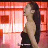 a woman in a black dress is standing in front of a red curtain and says in my house