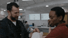 a doctor and a nurse are holding a baby in a hospital room .