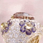 a ring with purple and yellow stones and diamonds