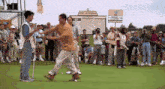 a man walking on a golf course with a sign that says at & t national