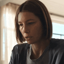 a close up of a woman 's face with a gray shirt