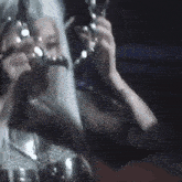 a woman with long white hair and a crown on her head is wearing headphones .