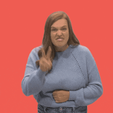 a woman in a blue sweater making a funny face