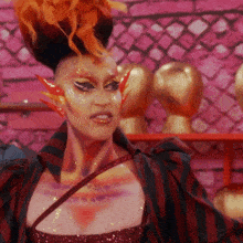 a woman with flames painted on her face is wearing a striped shirt