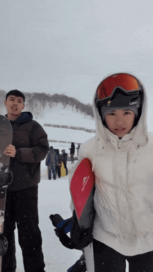 a snowboarder wearing a giro helmet holds a snowboard