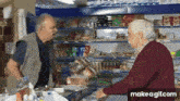 two older men are standing in a store talking to each other with make a gif.com at the bottom