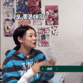 a woman wearing a blue and gray striped hoodie with the name aran on the bottom right