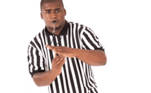 a referee wearing a black and white striped shirt is making a stop sign