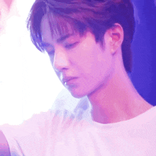 a close up of a person 's face with a purple light behind them