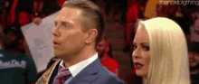 a man and a woman are standing next to each other in a ring .