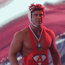 a wrestler with a medal around his neck and a letter a on his chest